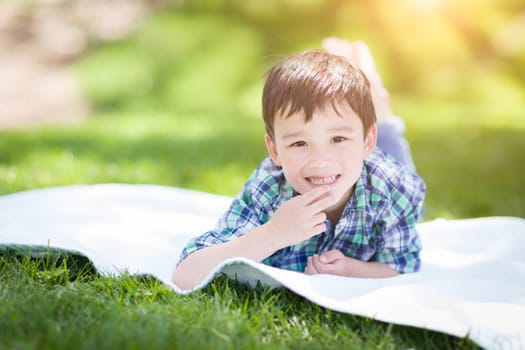 Mixed Race Chinese and Caucasian Young Boy Relaxing Outside On The Grass
