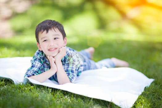 Mixed Race Chinese and Caucasian Young Boy Relaxing Outside On The Grass