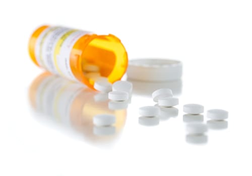 Non-Proprietary Medicine Prescription Bottle and Spilled Pills Isolated on a White Background.