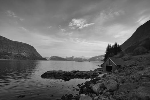 fishing lodge in norway on the fjord in black and white. historical view