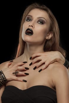 Portrait of a gothic woman with hands of vampire on her body on black background