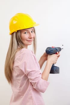 Young woman doing the DIY work and wearing protective helmet