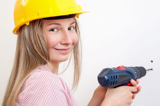 Young woman doing the DIY work and wearing protective helmet