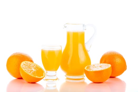 Orange juice in pitcher and oranges. Isolated on white background