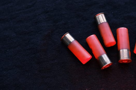 Shotgun shells on a black surface. Ammunition for 12 gauge smoothbore weapons. Hunting ammunition. Dark background