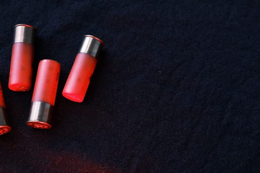 Shotgun shells on a black surface. Ammunition for 12 gauge smoothbore weapons. Hunting ammunition. Dark background