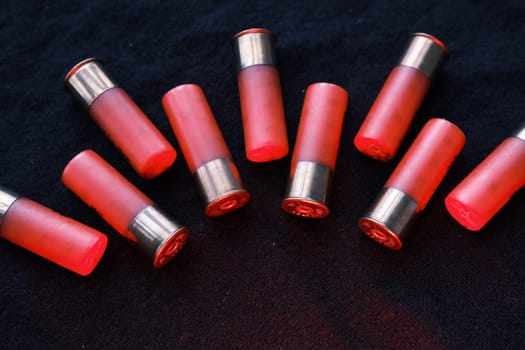 Shotgun shells on a black surface. Ammunition for 12 gauge smoothbore weapons. Hunting ammunition. Dark background
