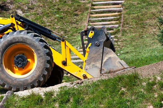detail yellow excavator traveling on the road