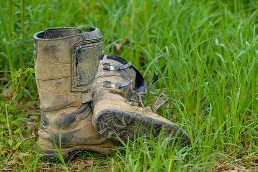 dirty motorcycle boots in the grass