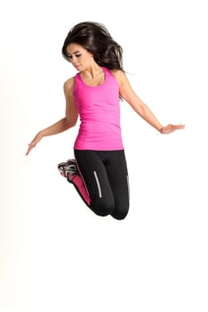 Weight loss fitness woman jumping high, female model isolated on white background in full body. Looking straight with some hair in her face.
