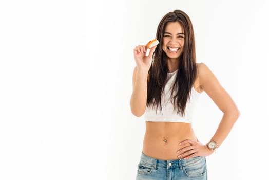 Young attractive asian caucasian woman holding sushi with her fingers, sexy fashion and pierced bellybutton, isolated on white background
