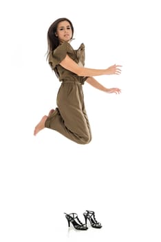 Young business woman jumping high with shoes on the ground over white background