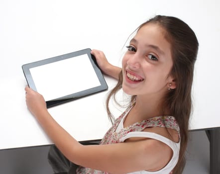 Beaitiful pre-teen girl using a tablet computer. High angle. Clipping path for the screen