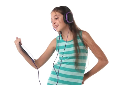 Beautiful pre-teen girl using a tablet computer and headphones. Isolated