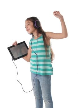 Beautiful pre-teen girl dancing with a tablet and headphones. Isolated