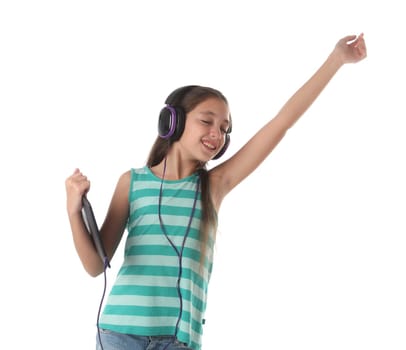 Beautiful pre-teen girl dancing with a tablet and headphones. Isolated