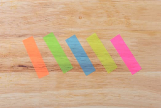 Notes five colours in diagonal on wood background