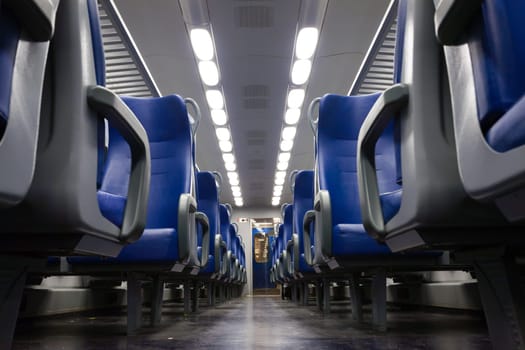 Perspective view of seats from the aisle inside a passenger train