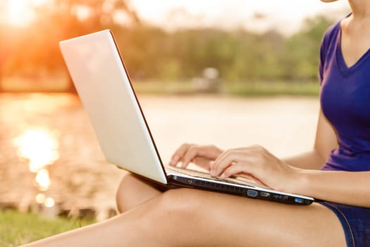 closeup women use laptop computer outdoor at sunset