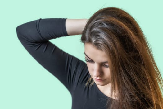 Portrait of beautiful sad girl on the green  background. Horizontally.