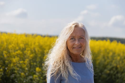 Portrait of a woman with bright hair in a rape field