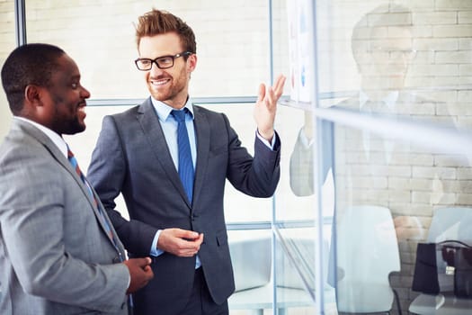 Two colleagues discussing business documents in office