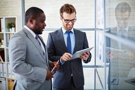 Two businessmen browsing in the net at meeting in office