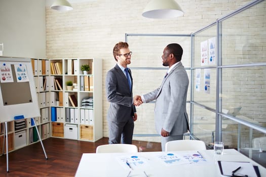 Confident managers handshaking in office after signing contract