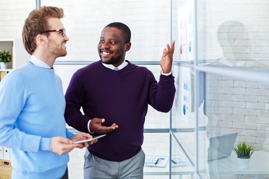 Confident male colleagues discussing statistic data in office