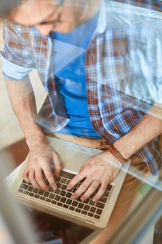 Young businessman typing on laptop keypad