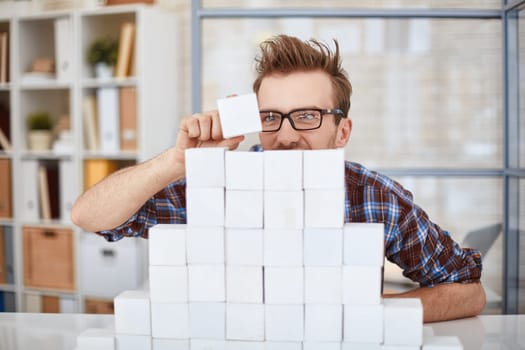 Creative businessman putting cube on top of paper pyramid