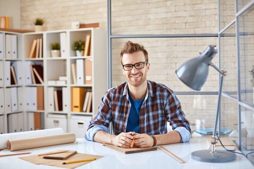 Businessman looking at camera from workplace