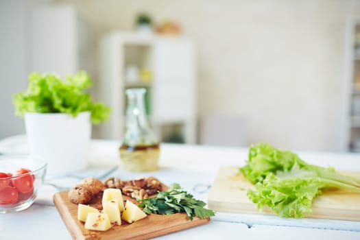 Fresh parsley, lettuce, tomatoes, walnuts and cheese on table