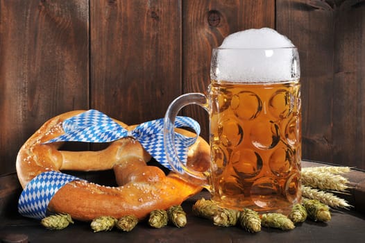 original Bavarian XXL Oktoberfestbreze with beer mug,hops and wheat on old beer barrel