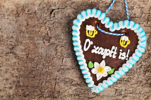 original Bavarian Oktoberfest gingerbread heart on real brown tree bark