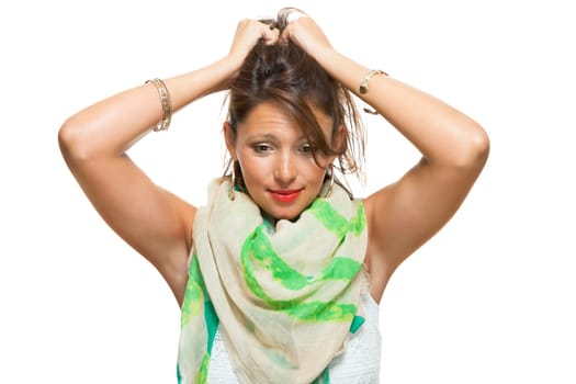 Portrait of a young brunette woman with her arms in her tousled hair isolated against a white background