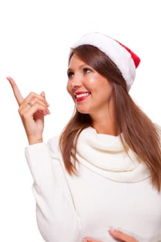 Young attractive woman with red Christmas hat points her finger in one direction isolated on white background