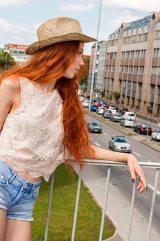 Attractive young woman with long root hair and straw hat outdoors in spring summer in blue sky