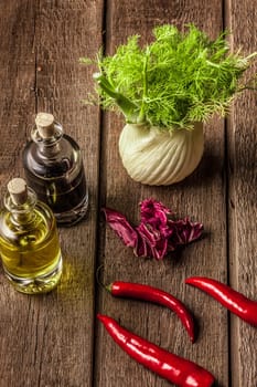 fresh fennel full of vitamins and fibers on wooden table. olive oil, balsamic vinegar, red pepper pods, bay leaves