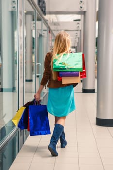 back view of  beautiful young woman with a shopping bags in the mall