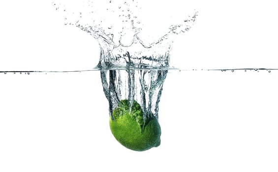 Fresh lime falling into water, isolated on white background