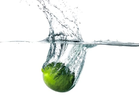 Fresh lime falling into water, isolated on white background