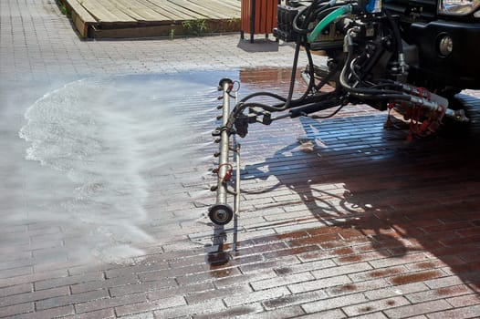 A special machine washes city paths and roads with water. High quality photo