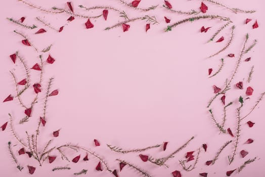 Floral pattern frame with flowers and petals over pink background. Flat lay border. Valentine's day design from above.