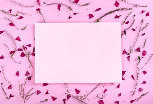 Floral pattern and empty valentine card with flowers and petals over pink background top view. Flat lay frame. Valentine's day design greeting card from above.