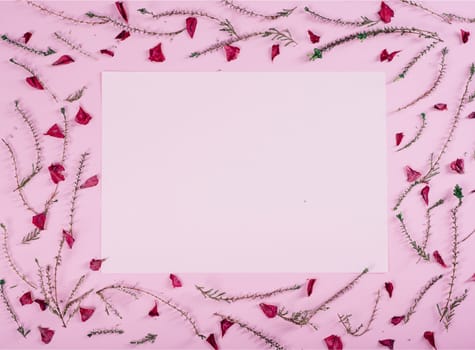 Floral pattern and empty valentine card with flowers and petals over pink background top view. Flat lay frame. Valentine's day design greeting card from above.