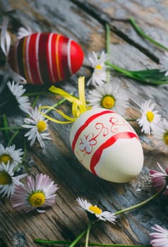 Easter eggs and spring daisy flower on rustic wooden background. Still life easter concept.