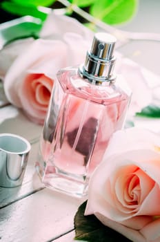 Bottle of perfume and pink wedding roses bouquet decoration.