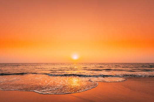Sunset Sun Above Sea. Natural Sunrise Sky Warm Colors Over Ripple Sea. Ocean Water Foam Washing Sandy Beach At Sunset.