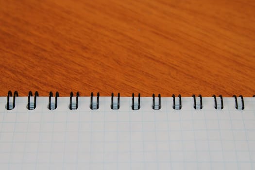 Notepad on a wooden table with copy space. View from above. Design blank.